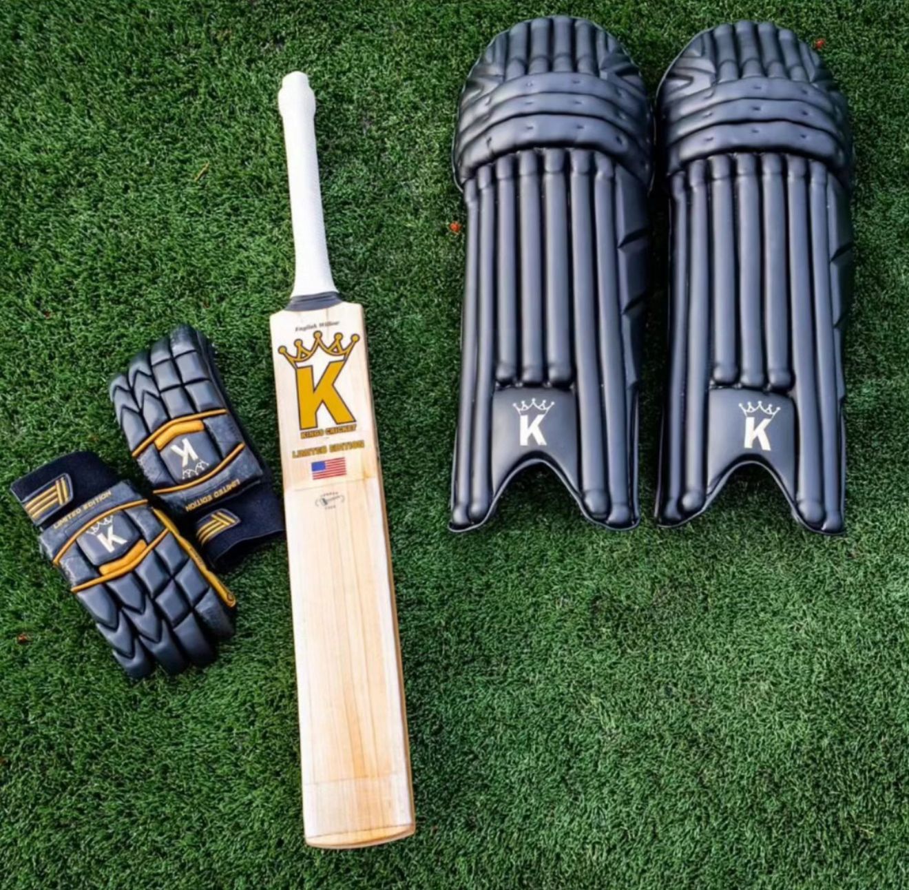 Cricketer's equipment including a bat, gloves, and pads on grass
